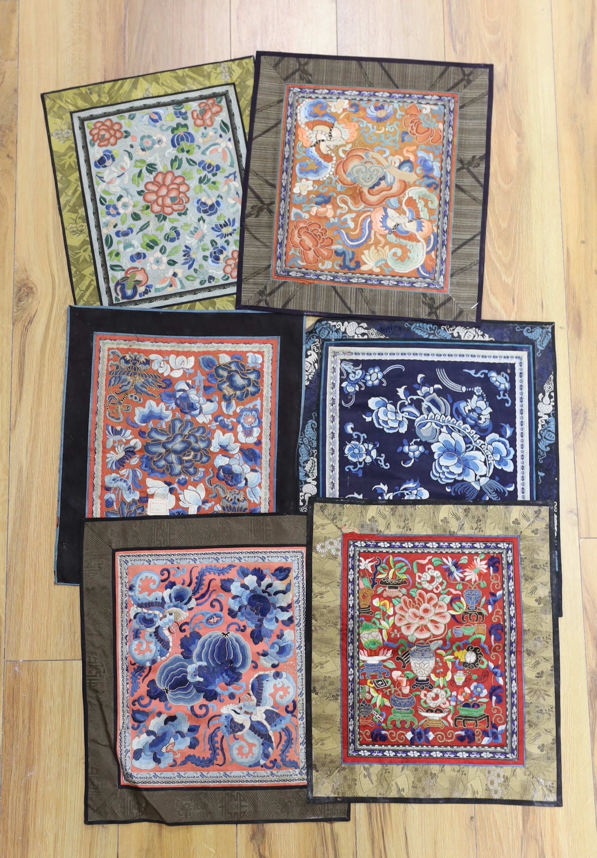 Six panels of Chinese silk embroidered mats, all using mixed stitches including Beijing knot, all bordered with silk brocade, largest 35 x 40cm